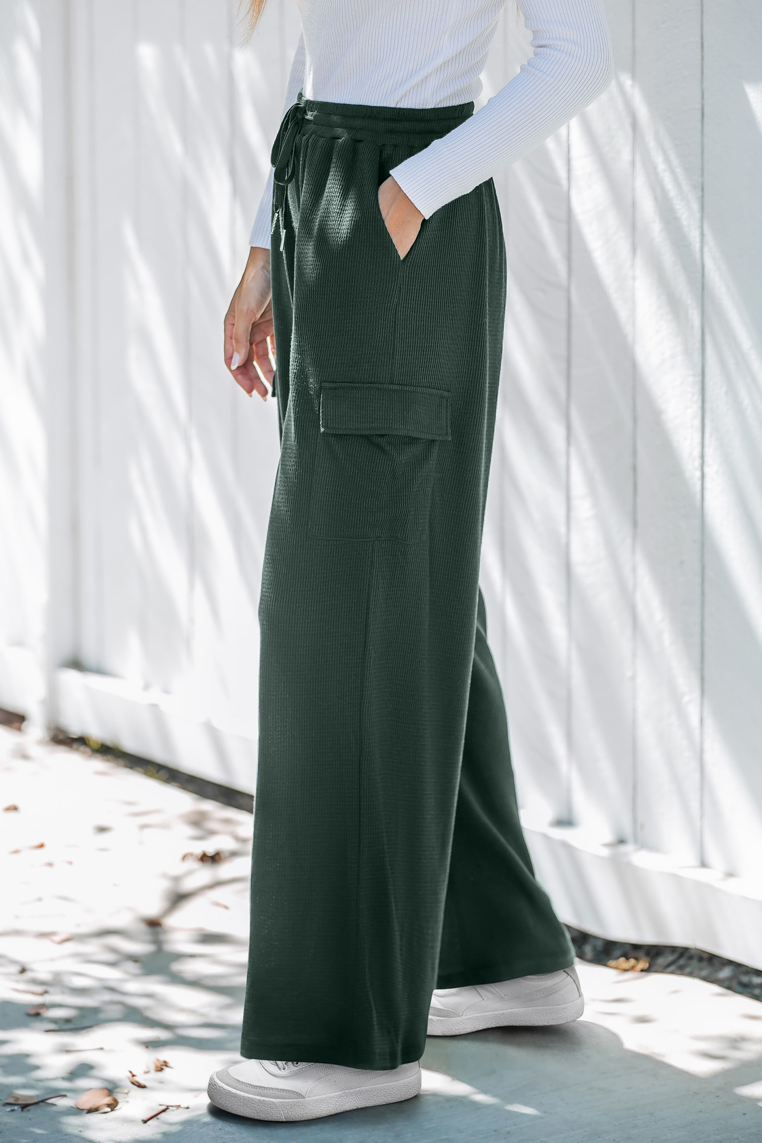 Zielone spodnie robocze ze ściągaczem w pasie i szerokimi nogawkami