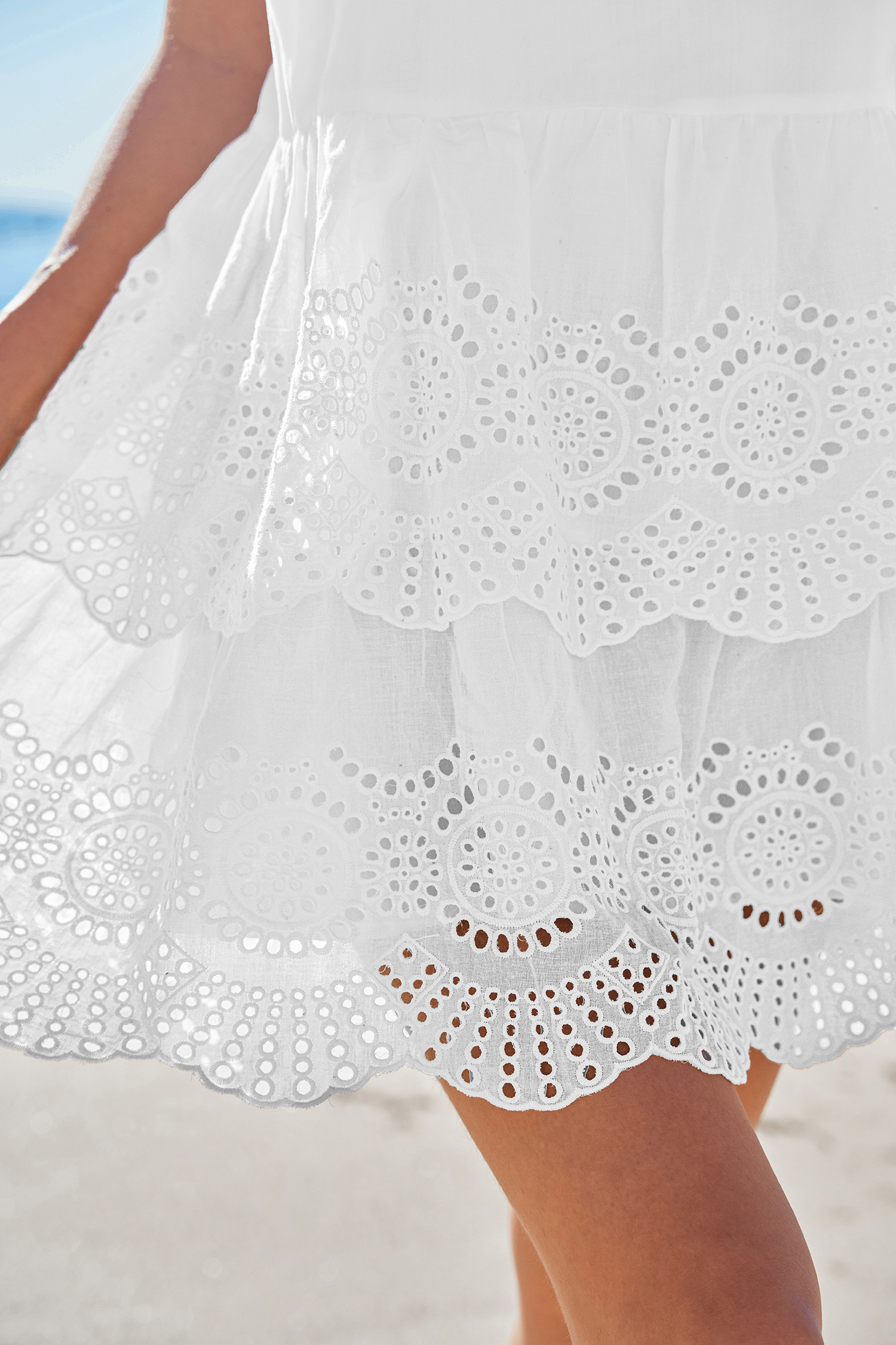 Robe courte à bretelles nouées et volants avec œillets