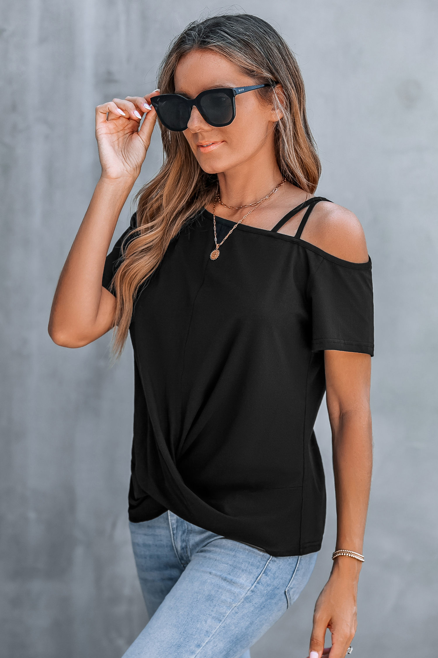 Camiseta negra con corte asimétrico y hombros retorcidos