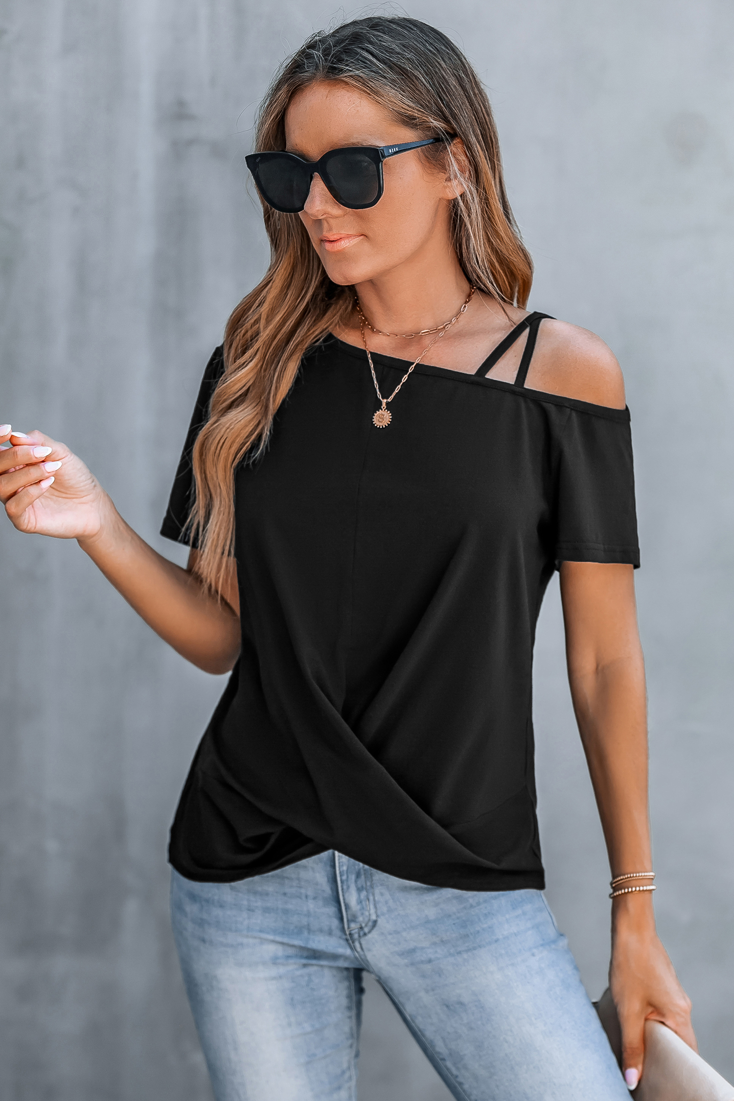 Camiseta negra con corte asimétrico y hombros retorcidos