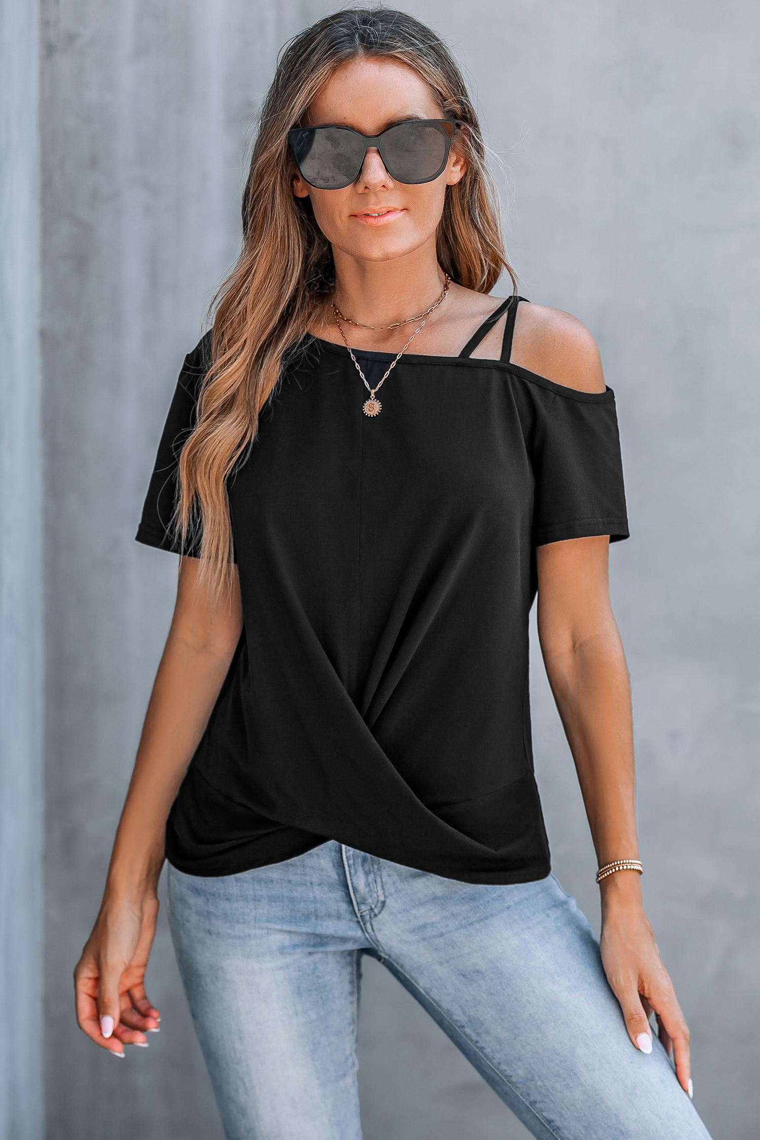 Camiseta negra con corte asimétrico y hombros retorcidos